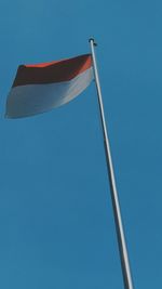 Low angle view of flag against blue sky