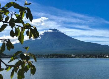 Scenic view of sea by mountains against sky