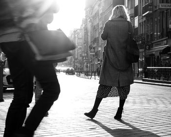 Rear view of woman standing on street in city