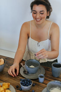 Smiling woman having breakfast