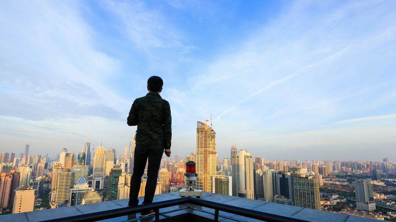 city, building exterior, architecture, built structure, sky, cityscape, skyscraper, cloud - sky, rear view, city life, cloud, men, standing, lifestyles, modern, tall - high, tower, leisure activity