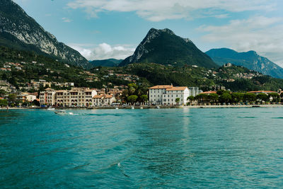 Scenic view of sea by buildings against sky