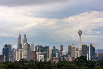 Buildings in city against cloudy sky