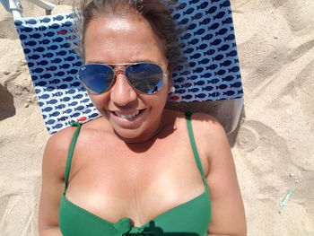 Portrait of smiling young woman in sunglasses at swimming pool