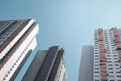 Low angle view of modern apartment buildings against clear blue sky