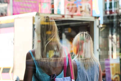 Rear view of two women walking on road