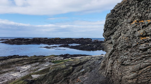 Rock formations by sea against sky