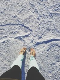 Low section of person standing on sand