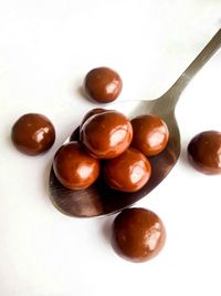 High angle view of candies on table against white background