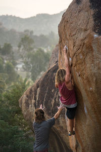 Rear view of women on rock against mountains