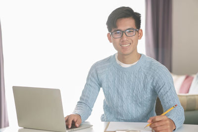 Portrait of smiling young man using mobile phone