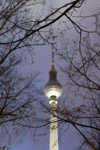 Low angle view of illuminated communications tower against sky