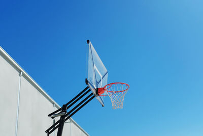 Low angle view of basketball hoop against blue sky