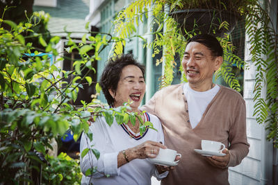 Happy friends with coffee and plants