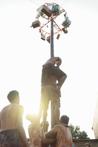 Low angle view of people against clear sky