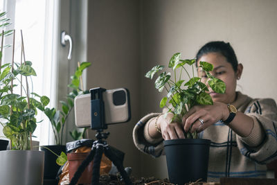 Woman vlogging about potted plants