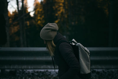 Side view of woman hiking in forest during winter