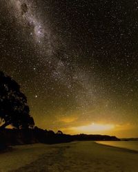 Scenic view of landscape against star field at night