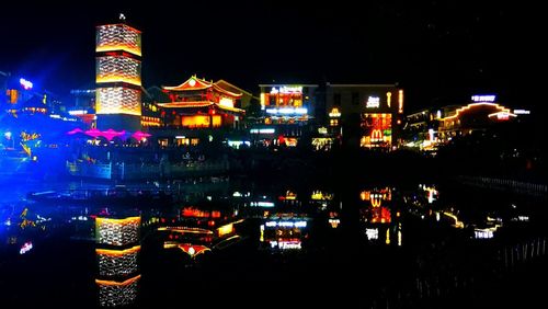 Illuminated cityscape against sky at night