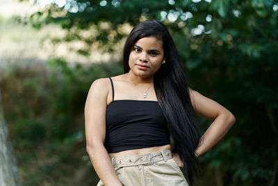 Portrait of beautiful woman standing against blurred background