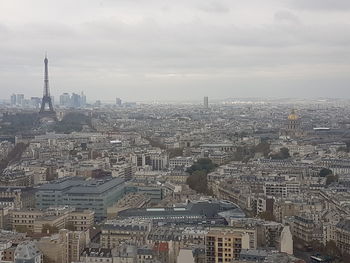 High angle view of city buildings against cloudy sky