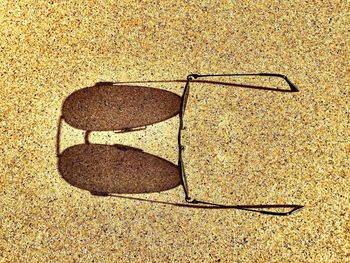 High angle view of sunglasses on sand