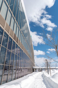 Low angle view of snow covered building against sky