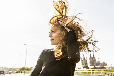 Germany, cologne, portrait of smiling woman with blowing hair