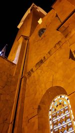 Low angle view of yellow building at night