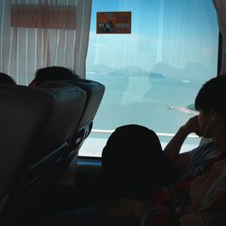 Rear view of couple looking through window