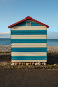 Hut on beach against sky