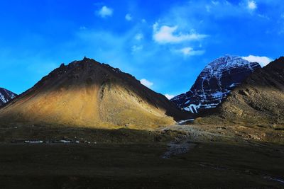 Scenic view of mountains against blue sky