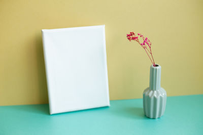 Cropped hand of woman holding blank paper against white background