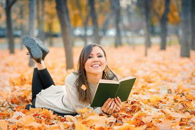 Young woman using mobile phone while standing in park