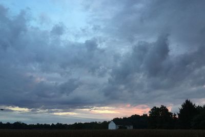 Silhouette landscape against cloudy sky