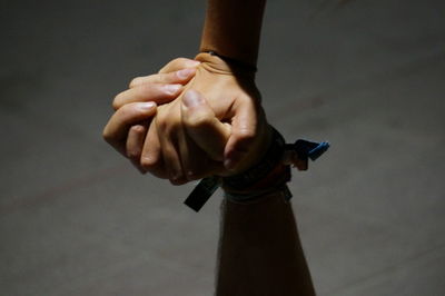 Cropped image of friends holding hands at footpath