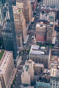 Aerial view of illuminated skyscraper buildings in city at day at high angle