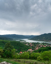 Scenic view of townscape by mountains against sky