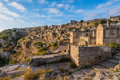 Houses on mountain at sassi di matera against blue sky