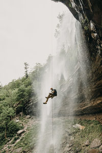 A man rappels a waterfall in the catskills, new york, new england