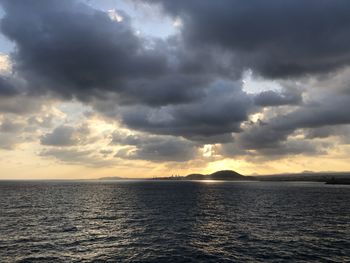 Scenic view of sea against dramatic sky during sunset