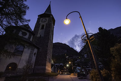 Low angle view of street light by building at night