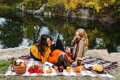 Group of people sitting by the lake