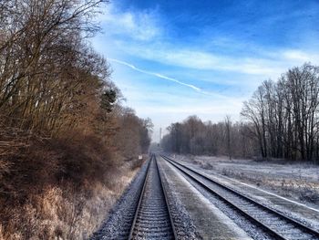 Railroad tracks against cloudy sky