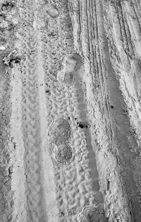 High angle view of footprints on wet sand