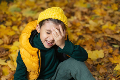 Portrait of young woman standing against yellow flower
