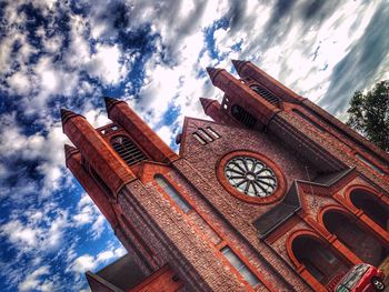 Low angle view of building against cloudy sky