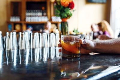 Cropped hand of man having alcohol at bar counter