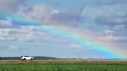 Scenic view of agricultural field against sky with a rainbow 