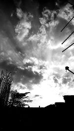 Silhouette of trees against cloudy sky